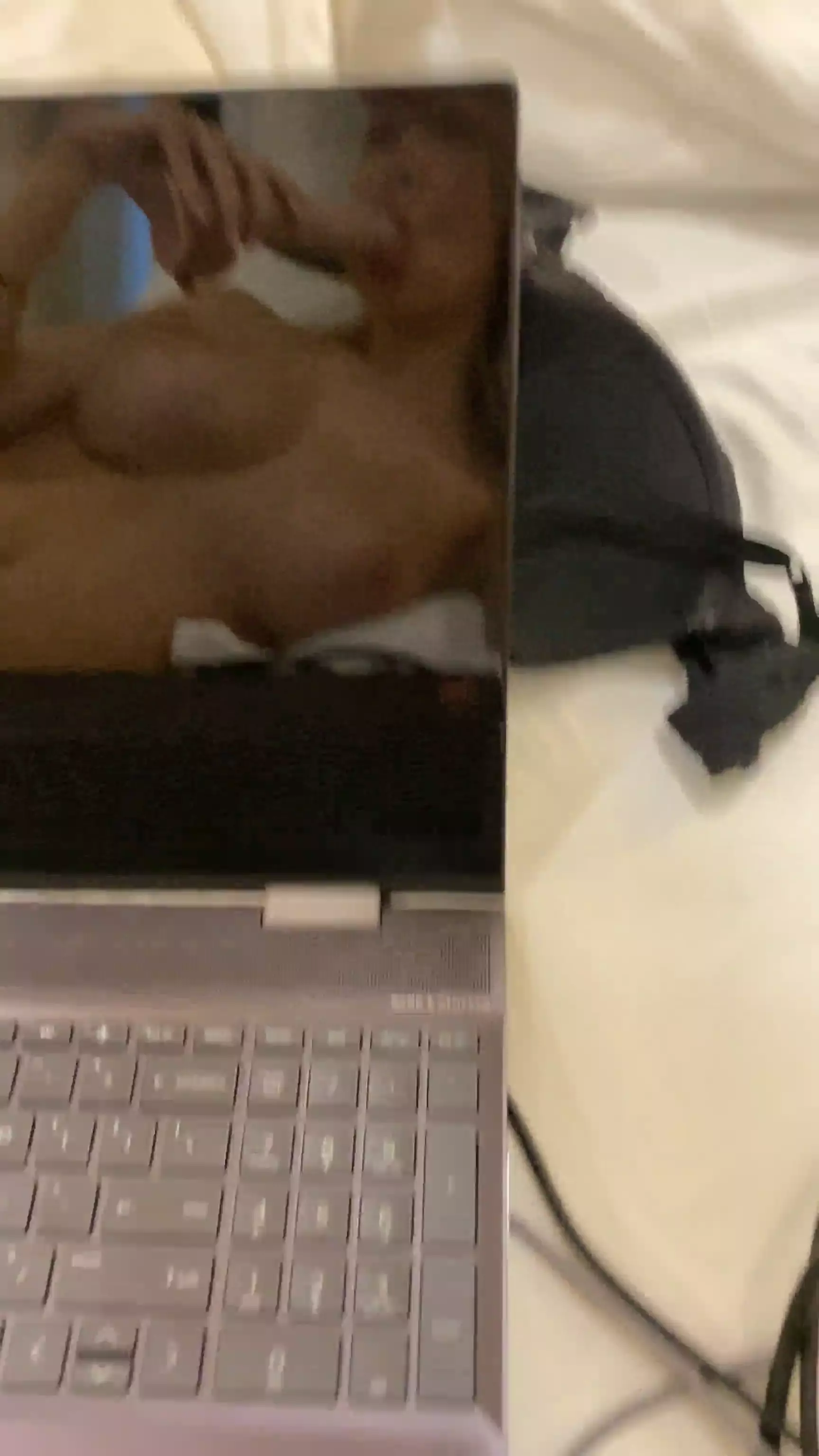 Kaylen Ward se divertindo com um consolo, se vendo no reflexo do MacBook Kaylen Ward se divertindo com um consolo, se vendo no reflexo do MacBook